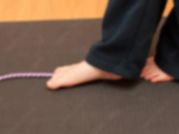 A child’s bare feet walking along a balance rope