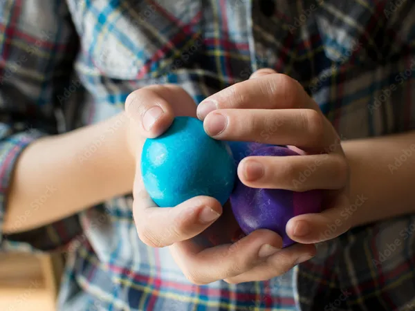 Small hands playing with textured balls