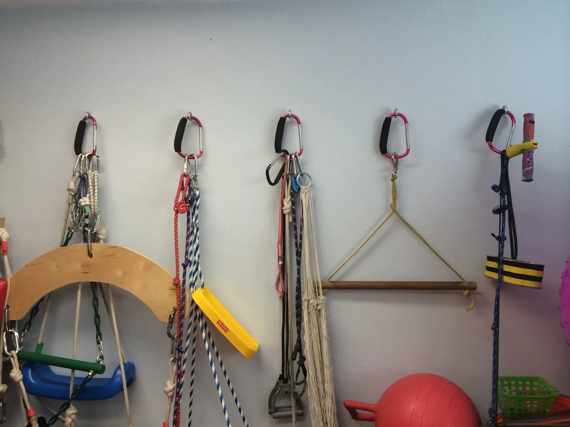Swings, ropes and therapy equipment hanging ready along the play-scape wall